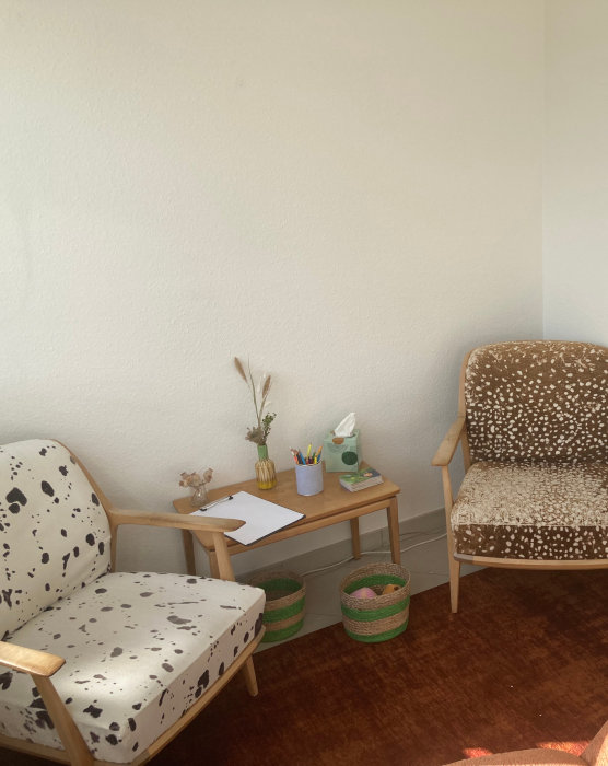 Espace de consultation avec deux fauteuils et une petite table en bois